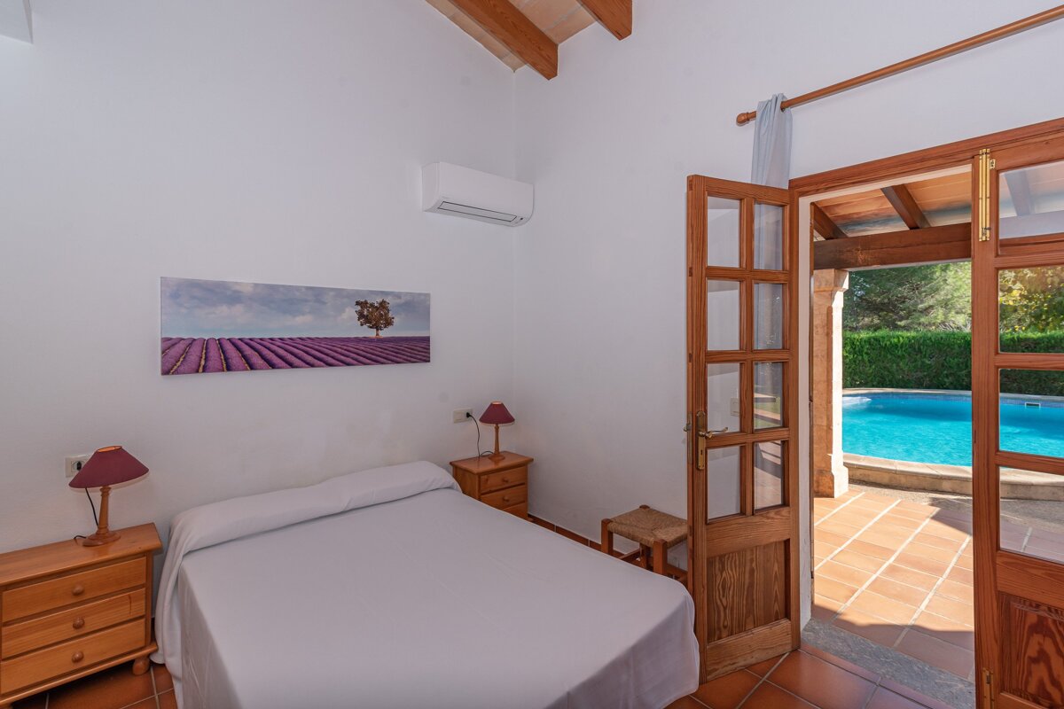 A bedroom with a bed and a painting on the wall