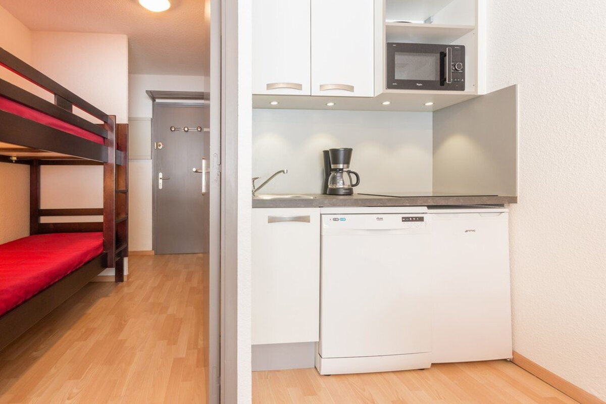 A small kitchen with a dishwasher and a coffee maker