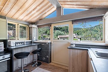 A kitchen with black stools and a large window