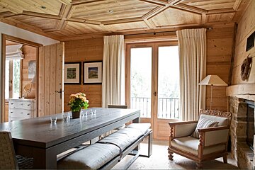 A wooden dining room with a table and chairs