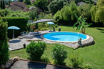A large swimming pool surrounded by chairs and umbrellas
