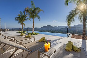 A swimming pool with a view of mountains and palm trees