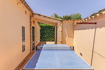 A ping pong table sits outside of a house