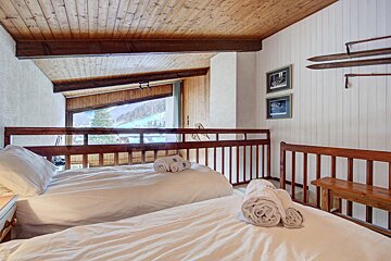 A bedroom with two beds and two towels on the bed