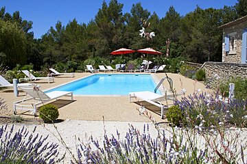 A large swimming pool surrounded by chairs and umbrellas