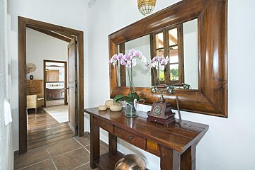 A wooden table with a mirror and a clock on it