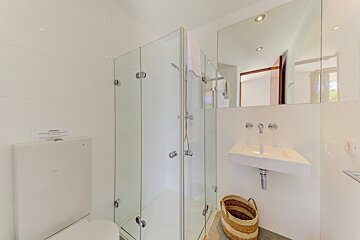 A bathroom with a toilet and a sink and a sign on the wall that says