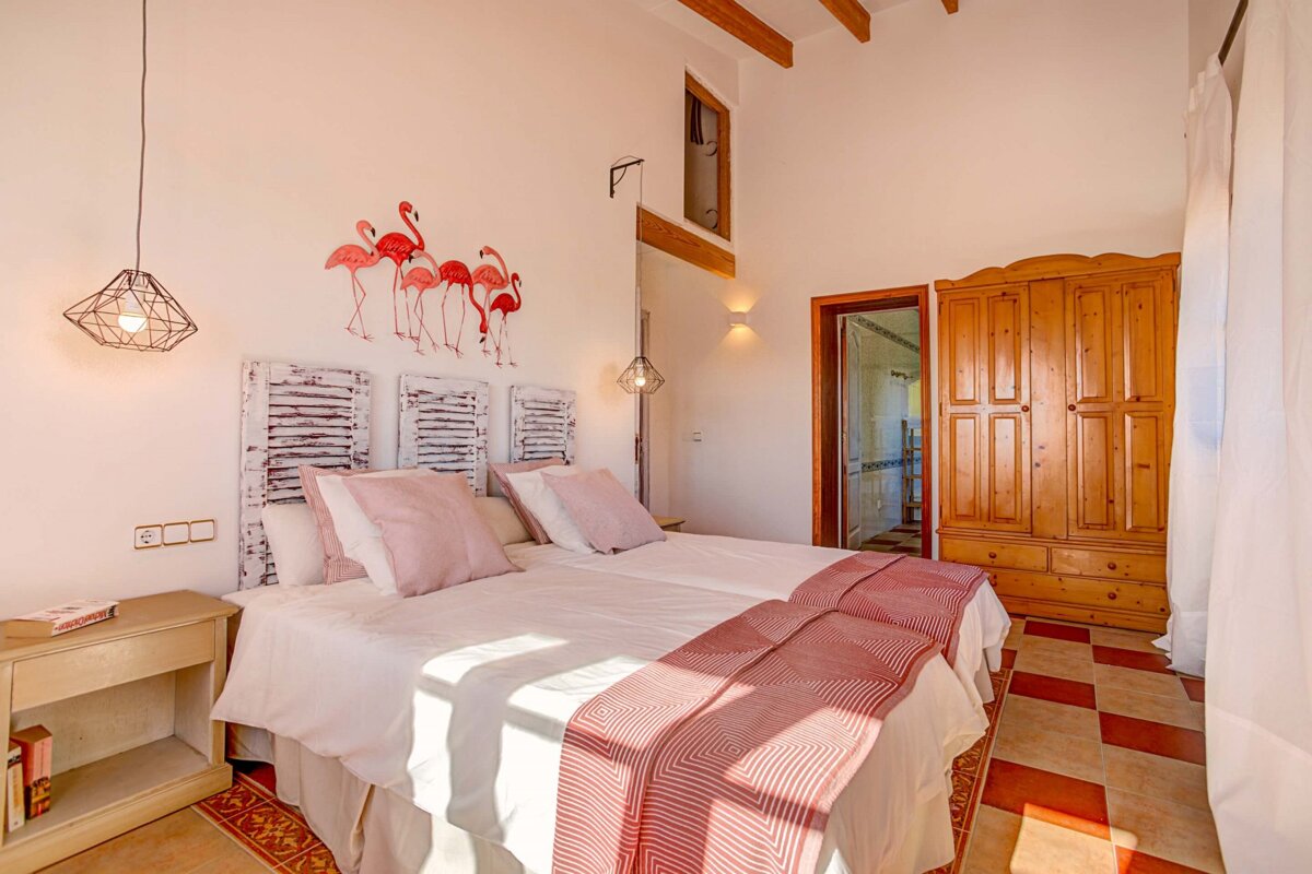A bedroom with two beds and flamingos painted on the wall