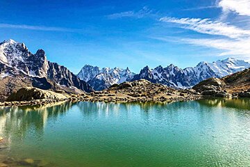 A lake with mountains in the background and a blue sky