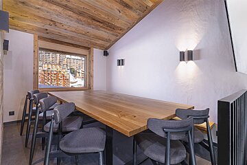 A room with a large wooden table and chairs