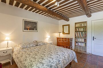 A bedroom with a large bed and a bookshelf with the word nature on it