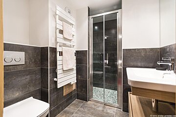 A bathroom with a toilet a sink and a towel rack