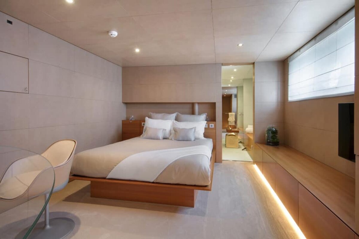 A bedroom with a large bed and a chair