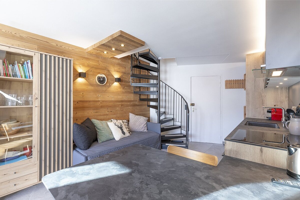 A small bedroom with a bed and a mirror