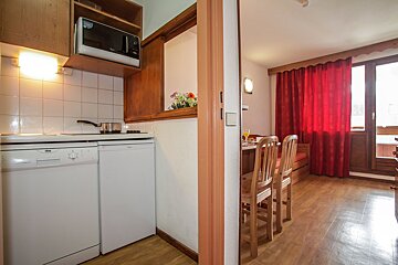 A kitchen with a dishwasher and a microwave above it