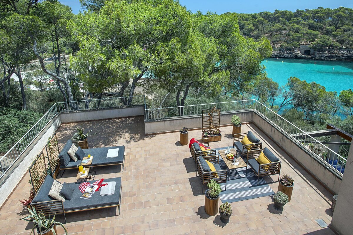A balcony with a view of the ocean and trees