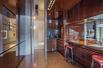 A kitchen with wooden cabinets and a stainless steel refrigerator