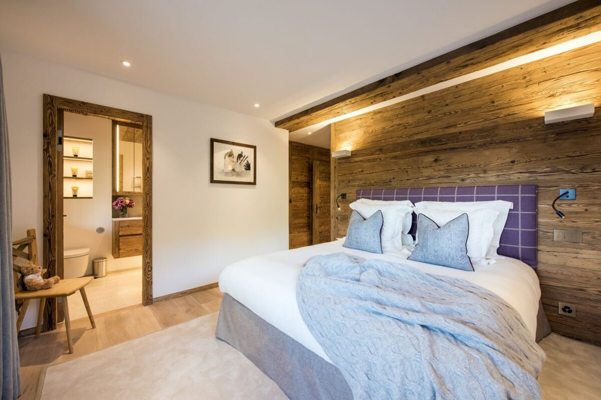 A bedroom with a bed and a picture on the wall