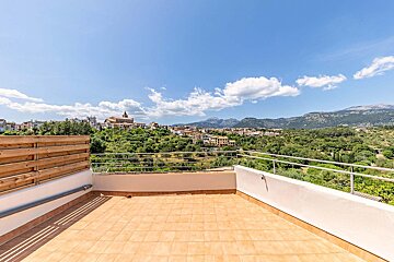 A balcony with a view of a city and mountains