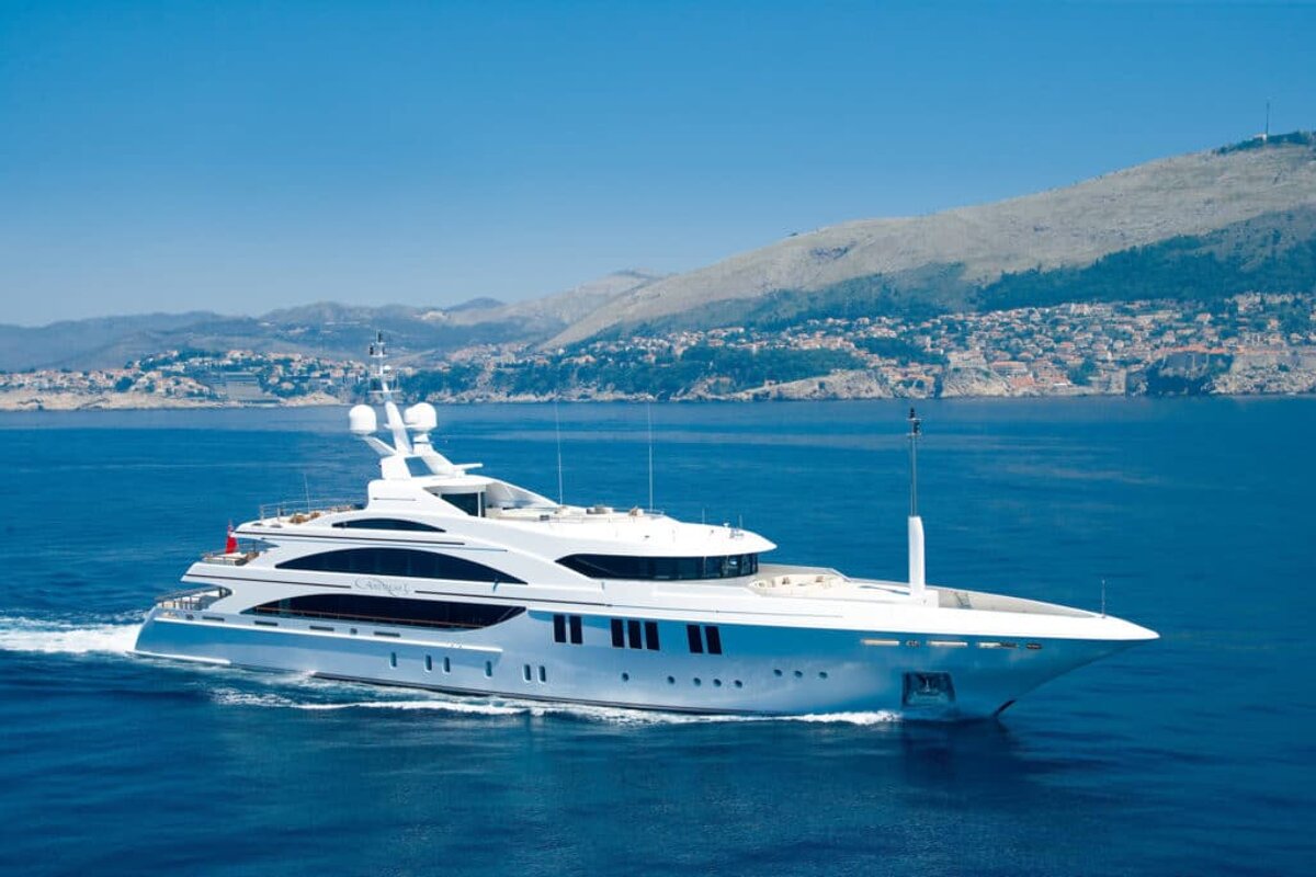 A large white yacht is floating in the ocean
