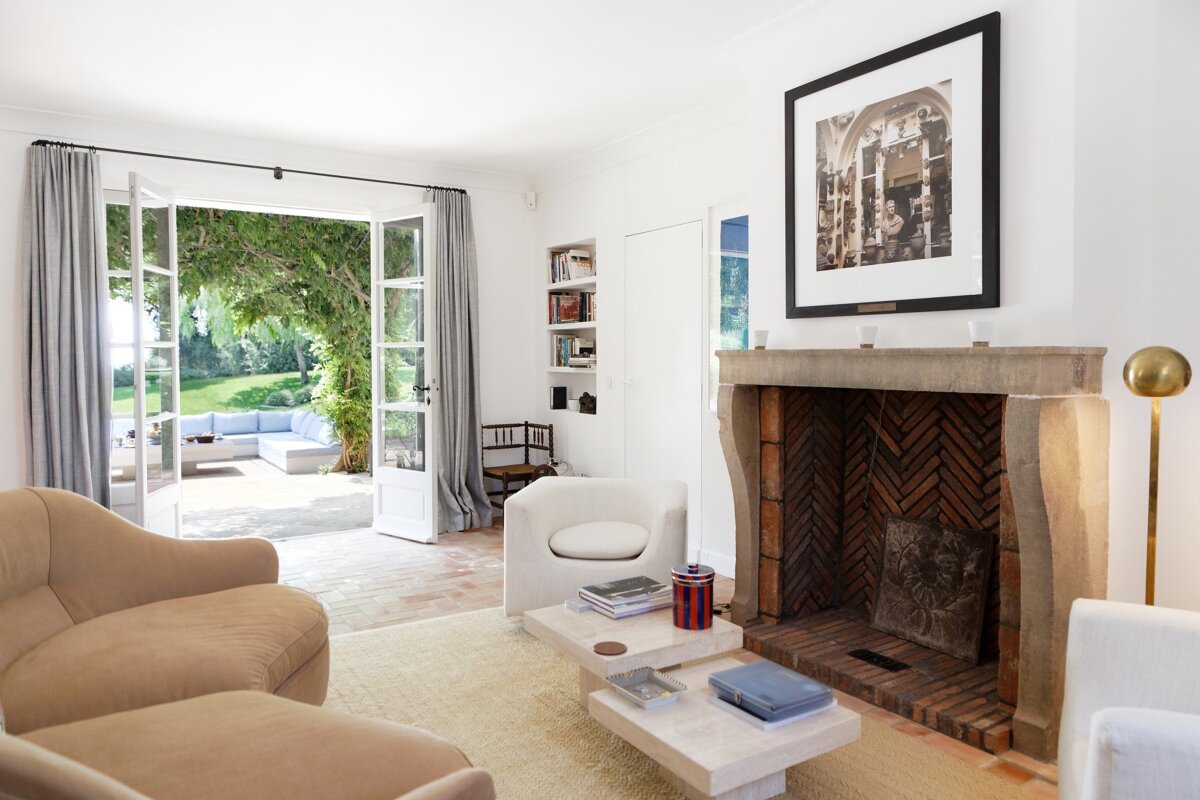 A living room with a fireplace and a picture on the wall