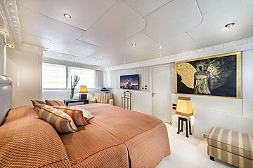 A bedroom with a large bed and a painting on the wall