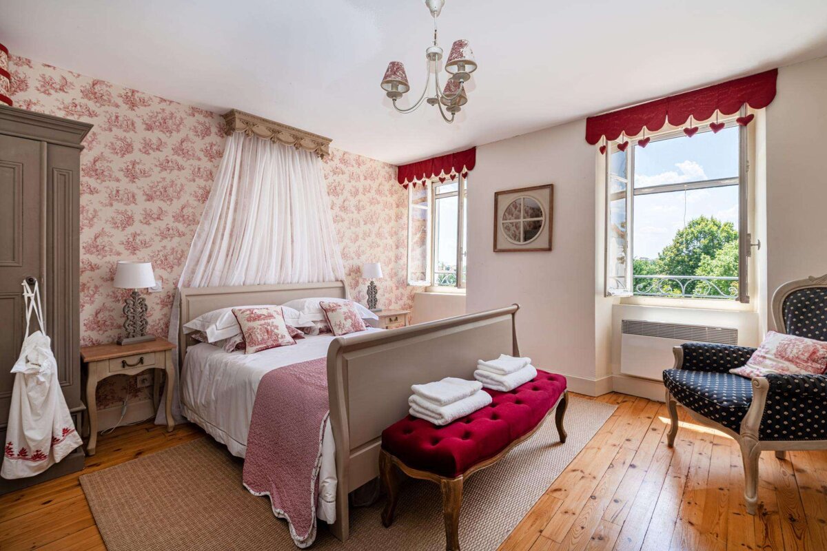 A bedroom with a bed a chair and a window