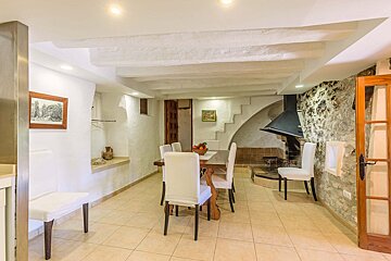 A dining room with a table and chairs and a fireplace
