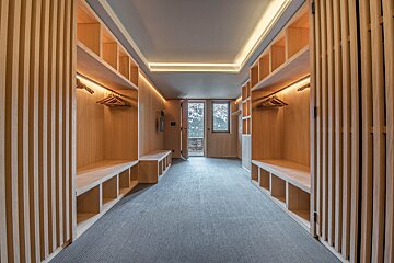 A walk in closet with wooden shelves and benches