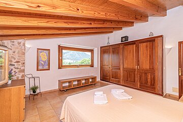 A bedroom with a large window and wooden cabinets