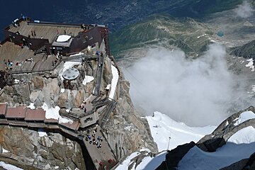A building on top of a snow covered mountain with stairs leading up to it