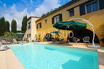 A large swimming pool in front of a house that says home sud