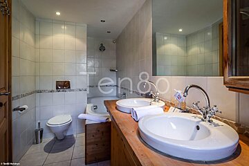 A bathroom with two sinks and the word ten80 on the wall