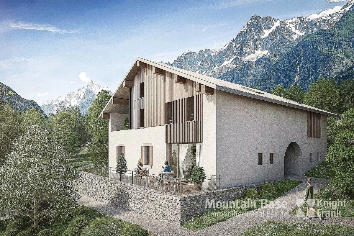 A striking modern alpine-style house with wood and white facade, featuring a terrace with people, set amidst lush trees and towering snow-capped mountains.