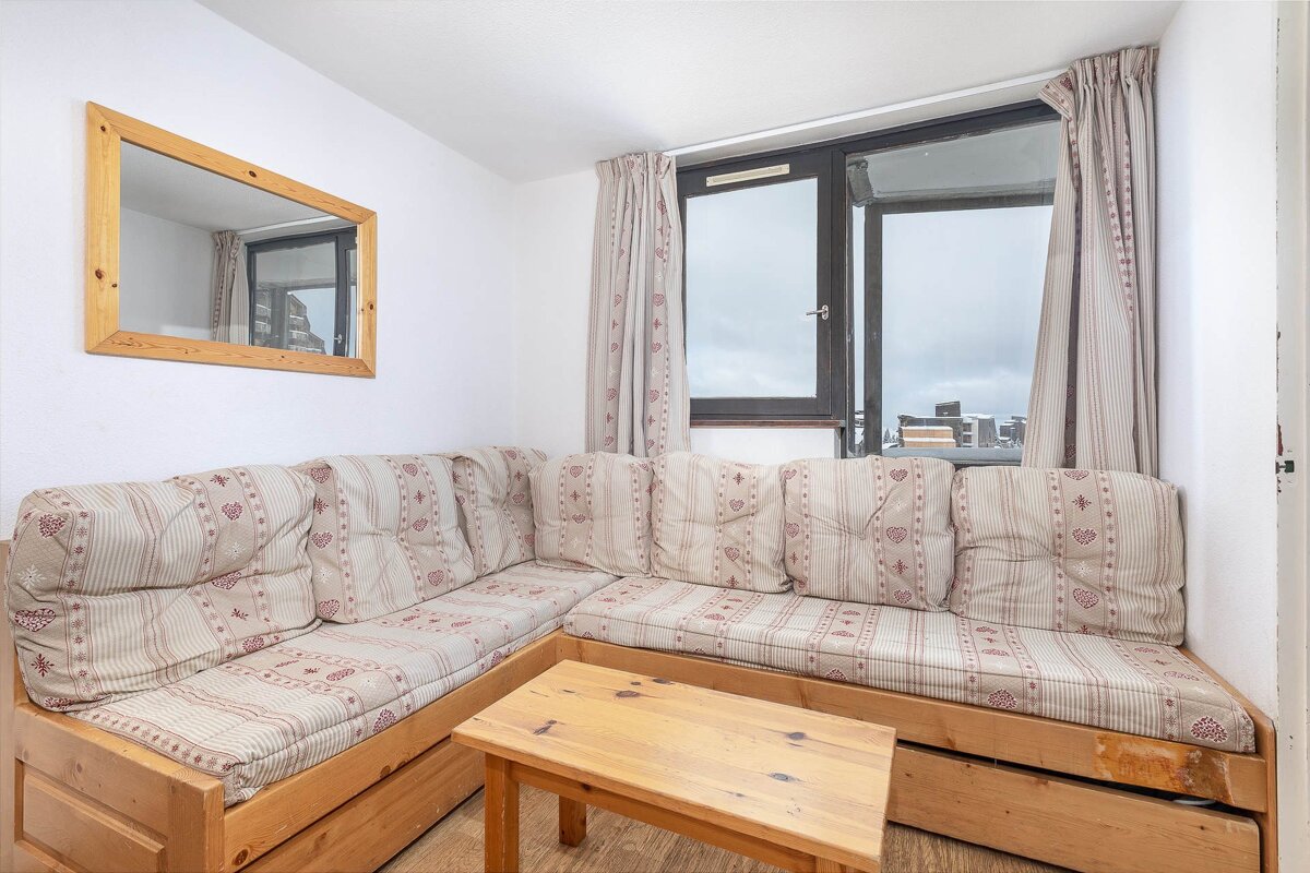 A living room with a couch a table and a mirror