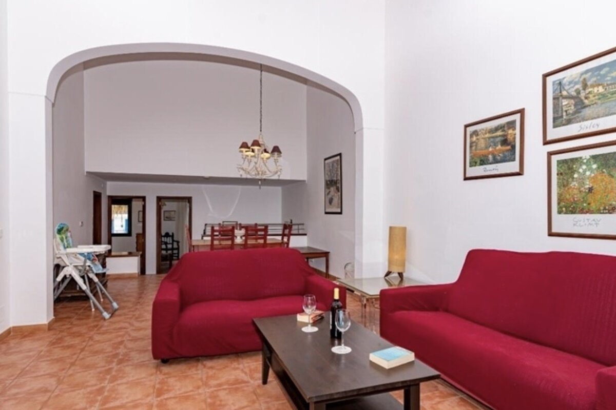 A living room with a red couch and a coffee table