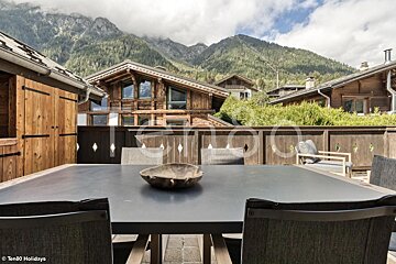 A table with a bowl on it and mountains in the background