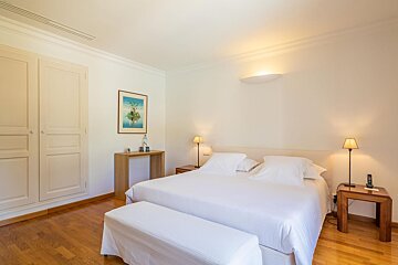 A bedroom with a large bed and a picture on the wall