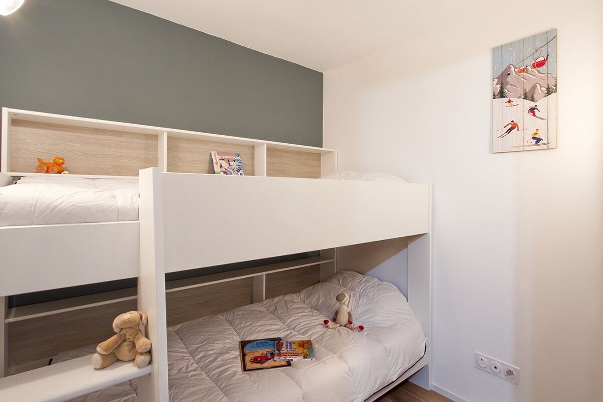 A bunk bed with a picture of skiers on the wall above it