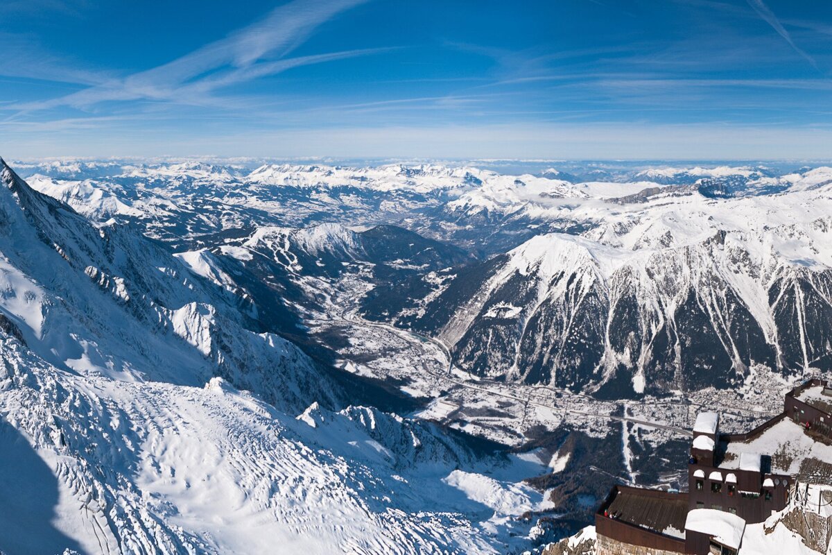 A view of a snowy mountain range with a building in the foreground