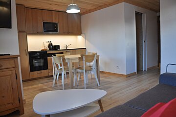 A kitchen with a table and chairs and a microwave