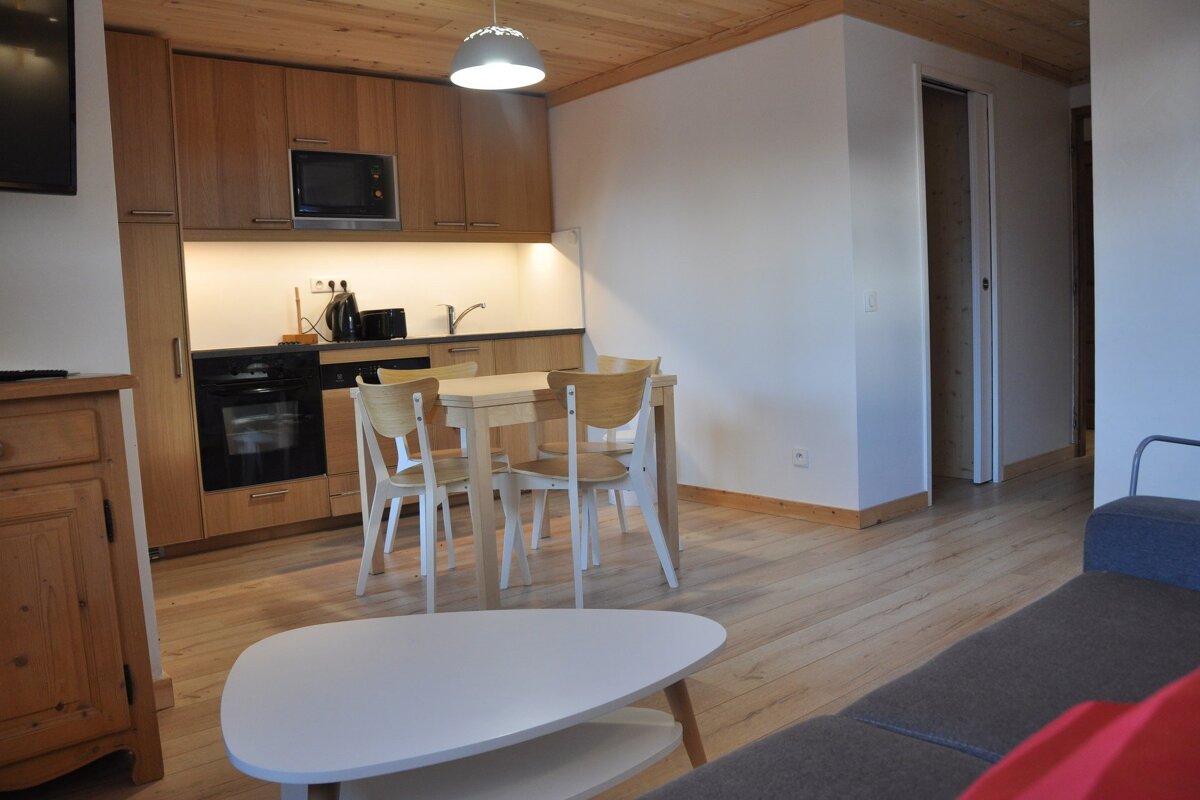 A kitchen with a table and chairs and a microwave