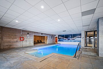 An indoor swimming pool with a picture of a swimmer on the wall