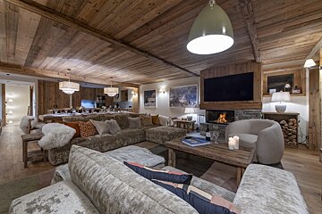 A living room with a large sectional couch and a fireplace