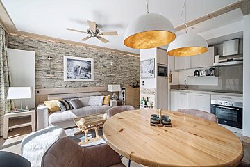A living room with a ceiling fan and a wooden table