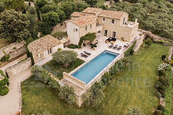 An aerial view of a large house with a large swimming pool