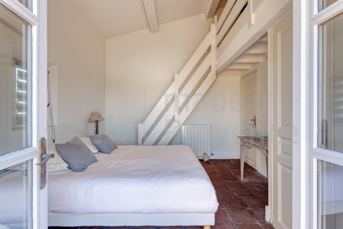 A bedroom with a staircase leading up to a loft
