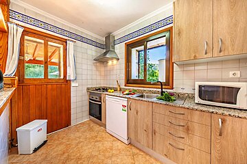A kitchen with wooden cabinets and a white microwave