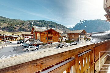 A balcony with a view of a mountain village and a sign that says alpine-p