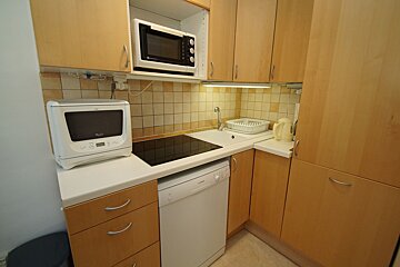 A kitchen with a whirlpool dishwasher and a microwave
